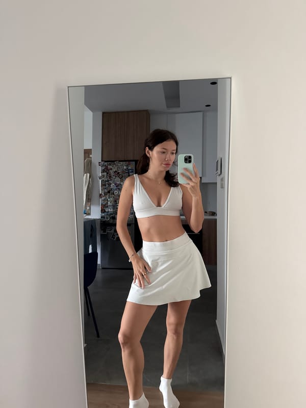 Woman takes mirror selfie in white athletic wear