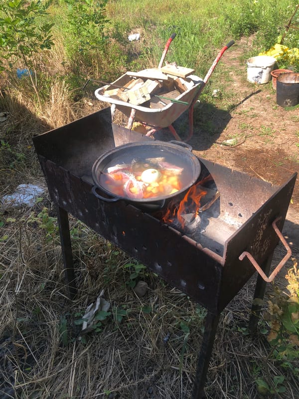 Open-fire cooking with cast iron pots in Lviv backyard