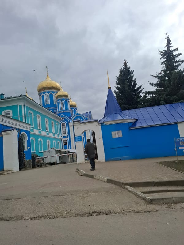 Pedestrians cross street near Orthodox monastery in Zadonsk, Russia