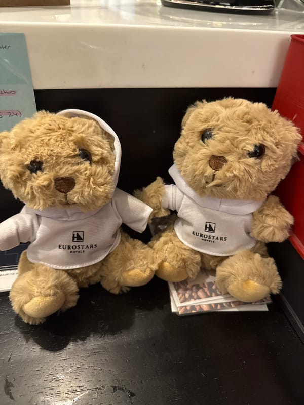 Hotel teddy bears arranged with containers, note in Munich