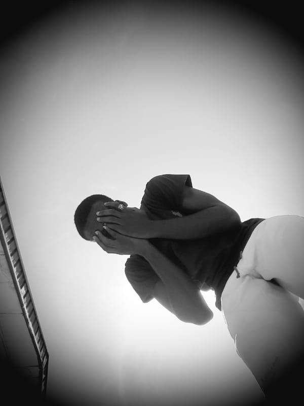 Person covers face in photograph captured in Narayi, Nigeria