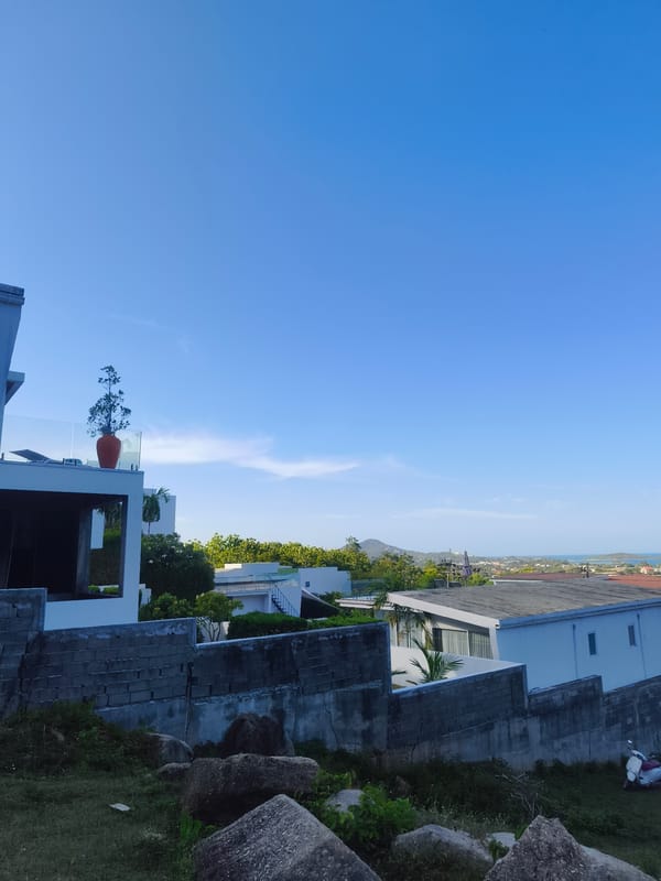 Hilltop Buddha statue overlooks Ko Samui's coastline on a clear morning