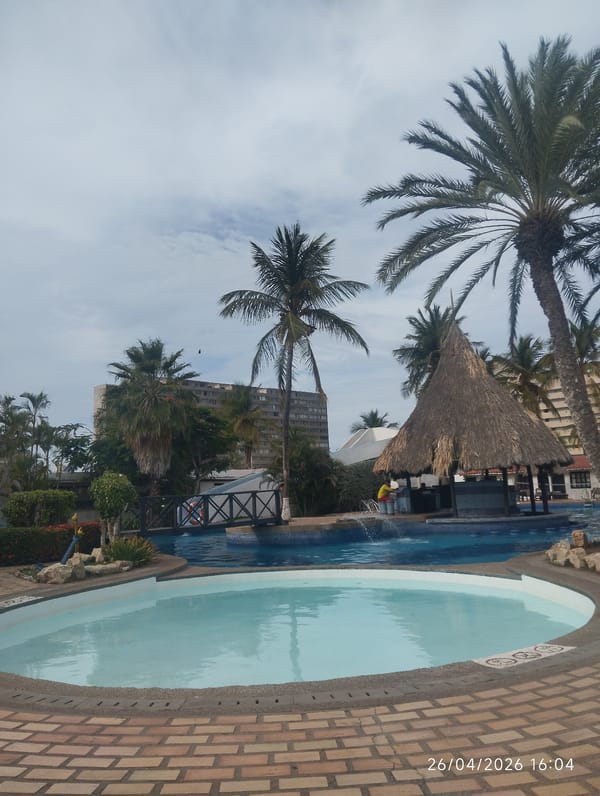 Person enjoys evening at tropical resort pool complex