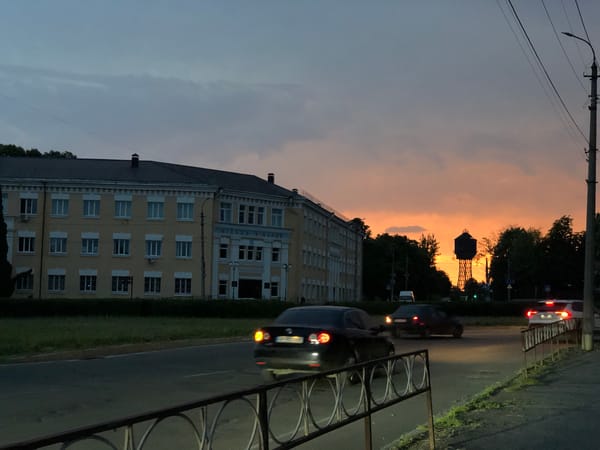 Yellow building anchors a busy city street at dusk