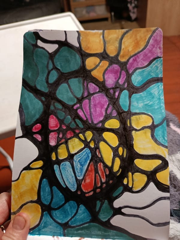 Artist creates colorful abstract drawings in notebook during evening session