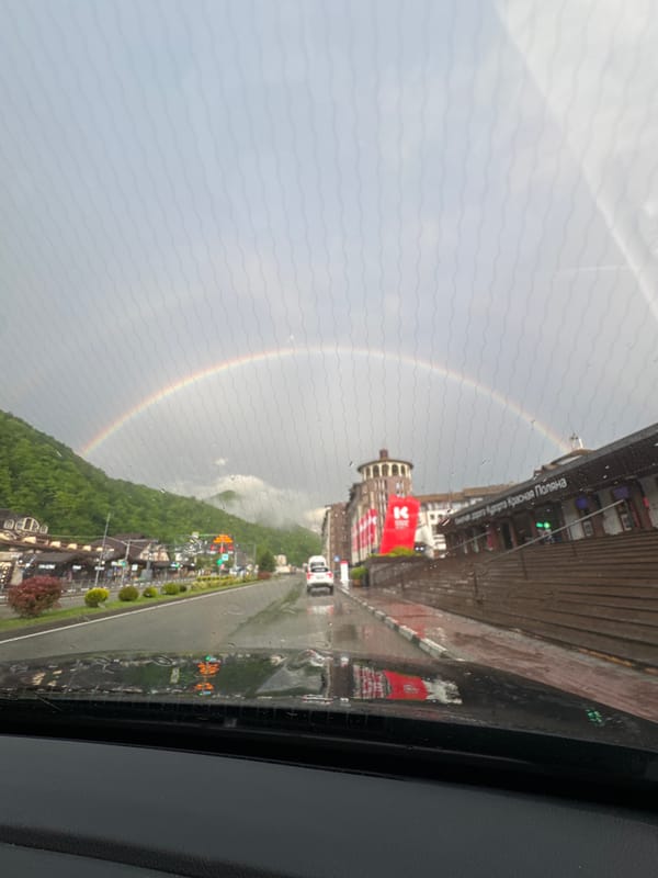 Rainbow appears over Russian mountain resort during afternoon rain