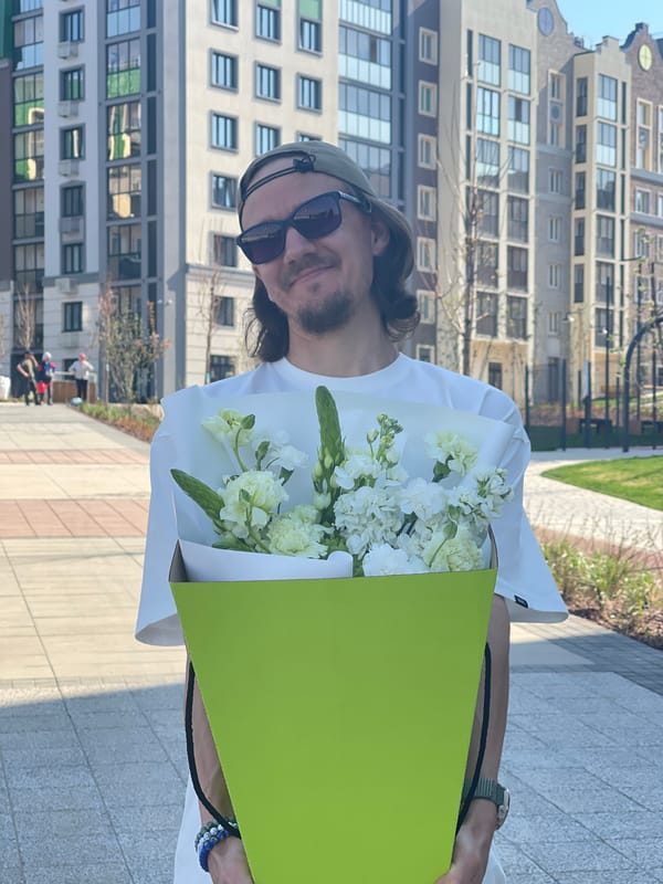 Man carries white flower bouquet in Хохряки, Russia