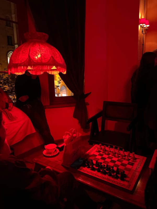 Evening social gathering documented in red-lit Tbilisi venue