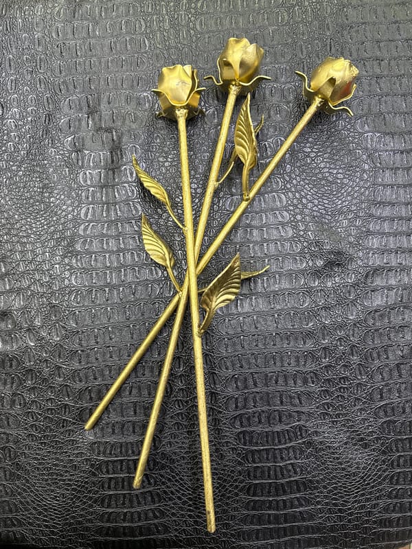 Golden metal roses displayed on black leather in Moscow