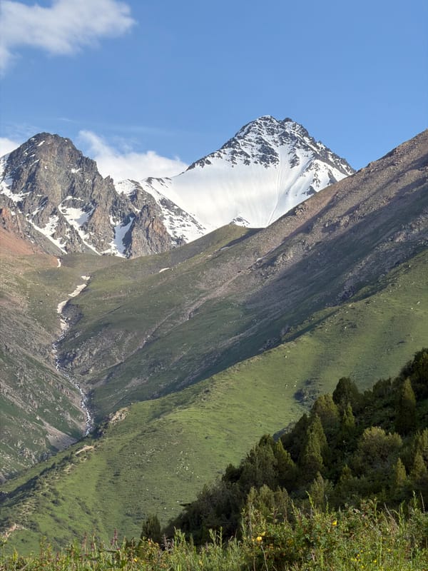Lush alpine valley and snow-capped peaks in Kashka Suu, Kyrgyzstan
