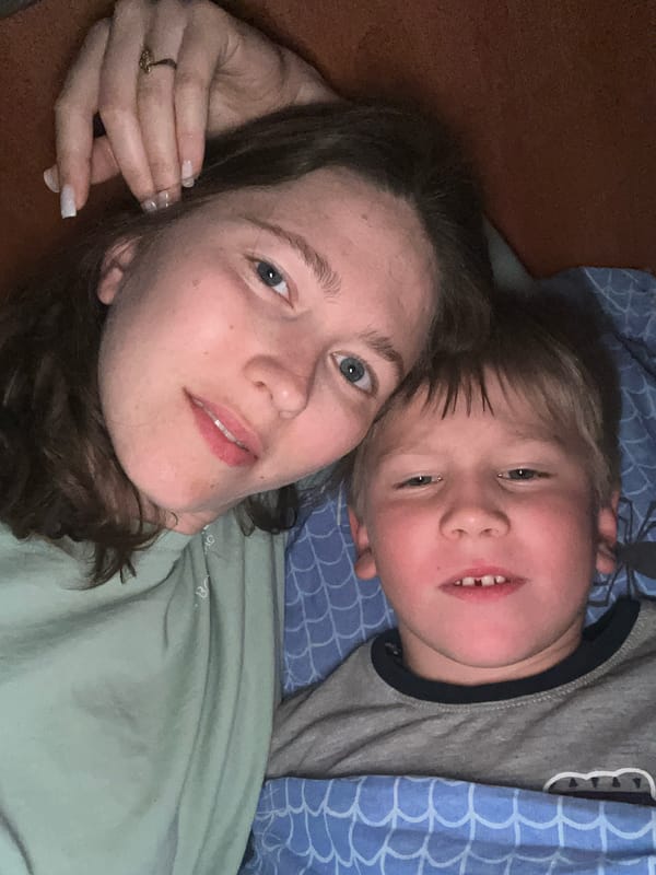 Woman and child share quiet moment on bed in Podgorica