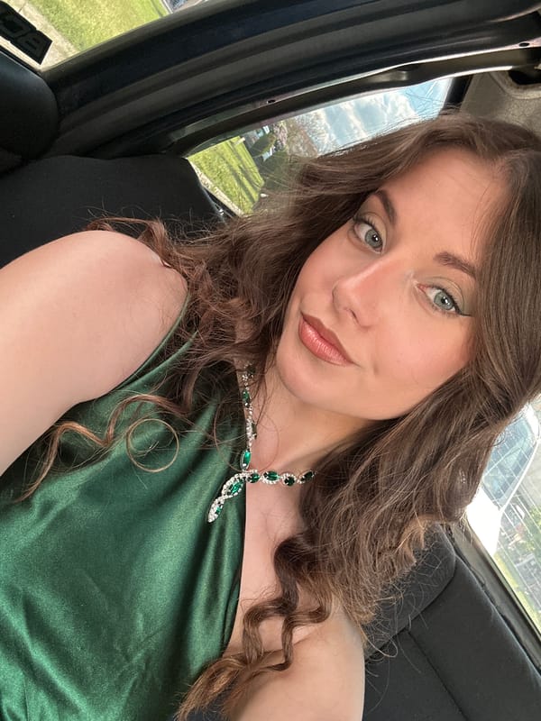 Woman in green dress takes car selfies