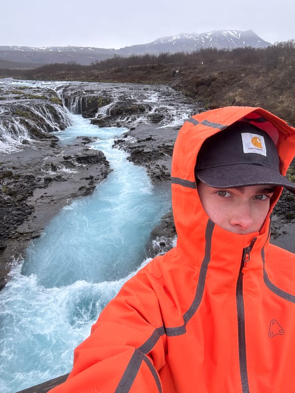 Tourist documents Iceland's Bruarfoss waterfall on overcast afternoon