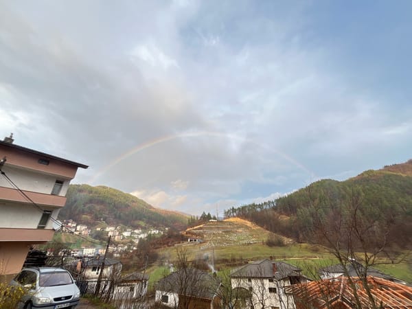 Rainbow appears over Chepintsi, Bulgaria hillside residential area