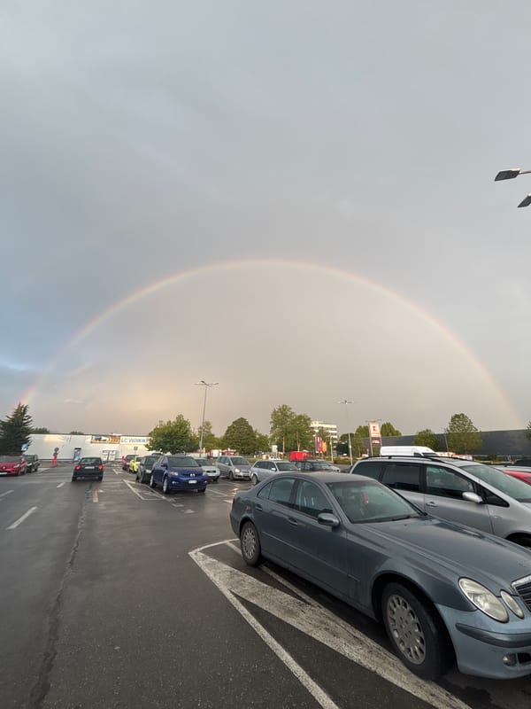 Rainbow appears over wet parking lot in Kazanlak, Bulgaria
