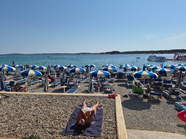 Sunny afternoon at a busy Croatian pebble beach