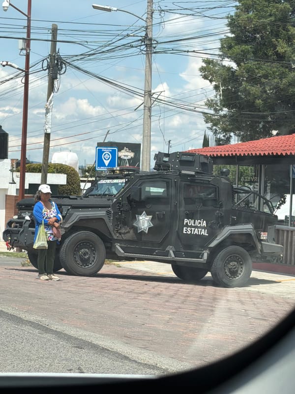 Armored state police vehicle on a brick sidewalk in Puebla