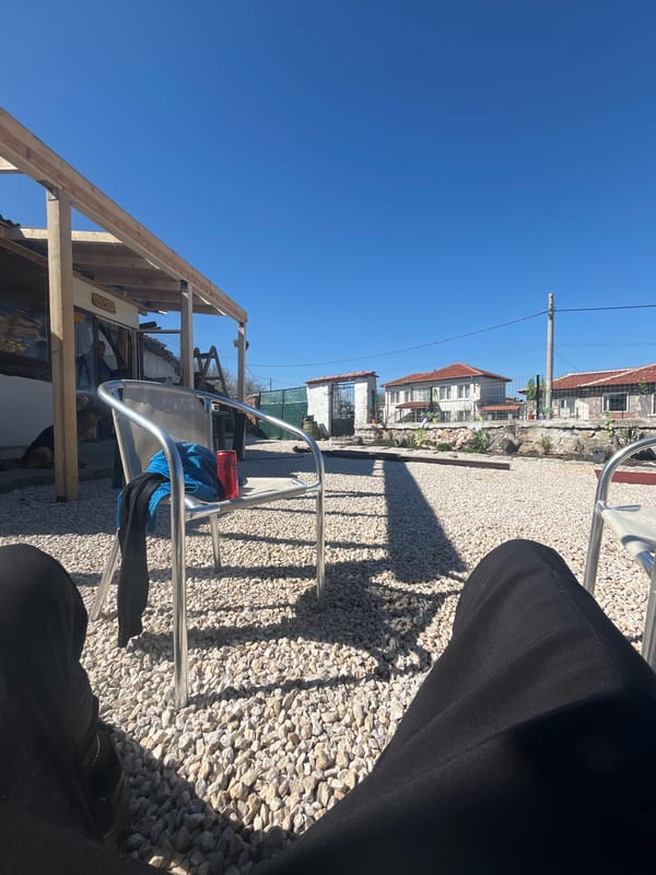 Person sits with belongings amid construction in Bulgarian village