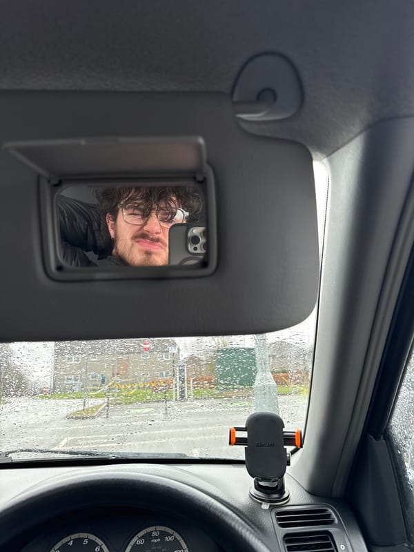 Man reflected in car mirror during rainy day