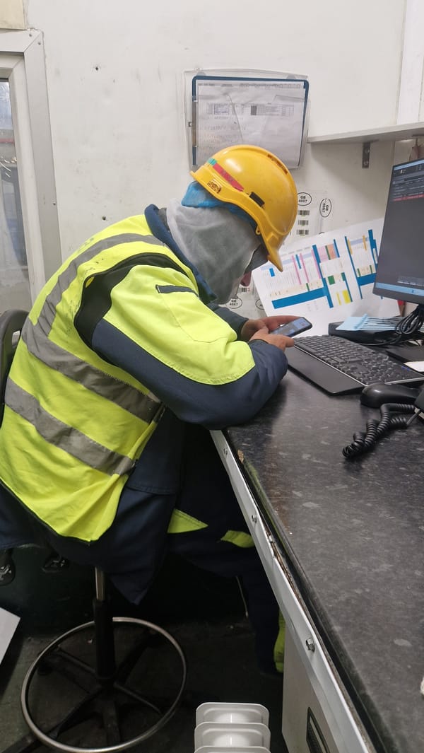 Safety worker uses phone at desk in Telford