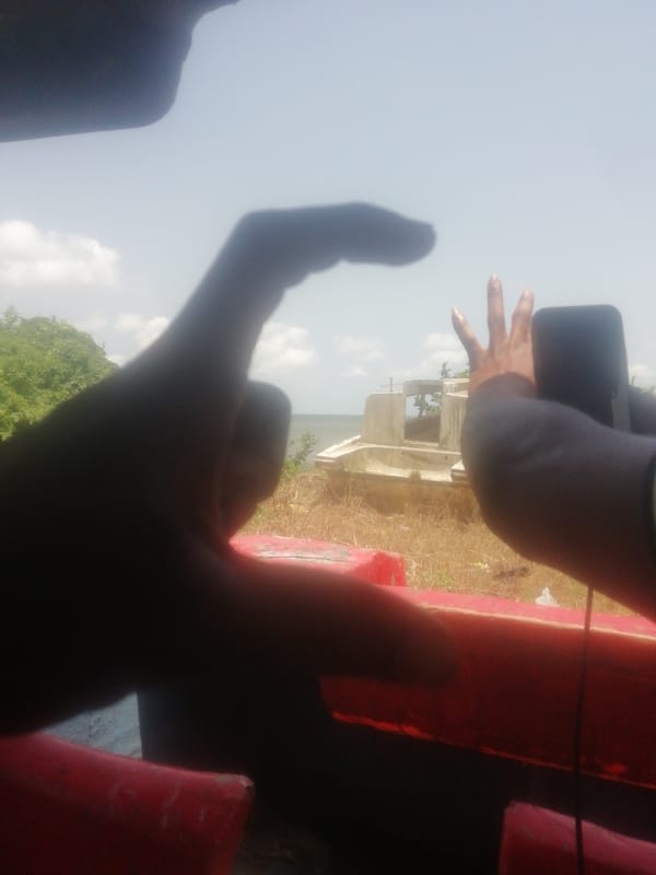 Person photographs abandoned boat from vessel in Ikorodu, Nigeria