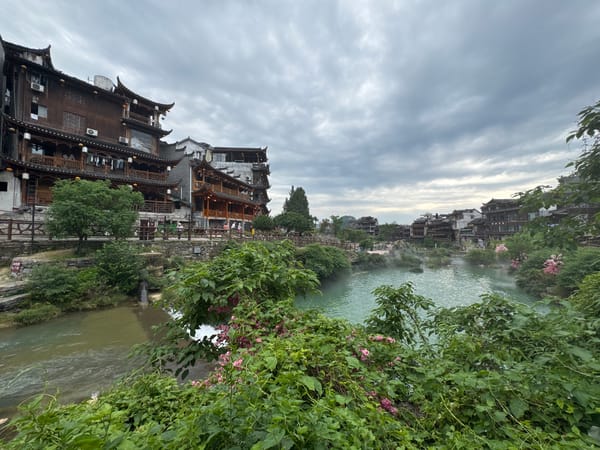 Morning mist rises over Furong Ancient Town river