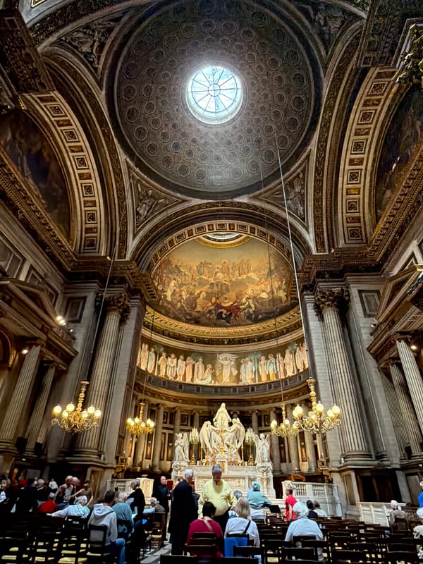 Visitor documents ornate interior of Madeleine Church in Paris