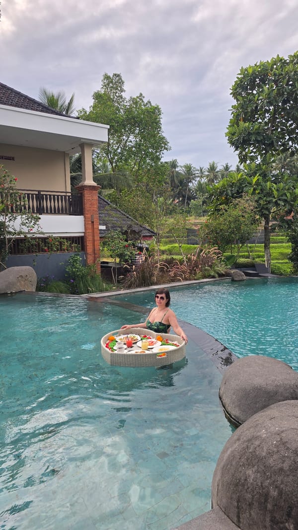 Woman enjoys floating pool service in tropical Ubud resort