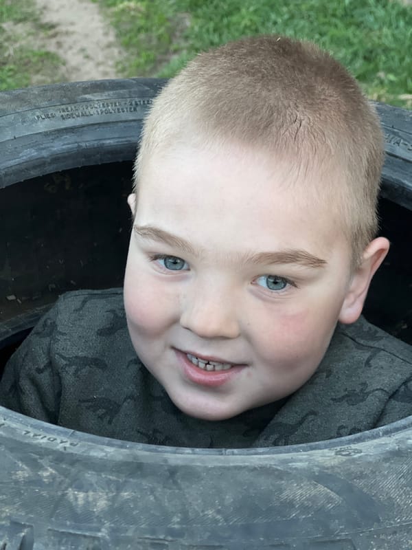 Boy plays in tire stack near Russian cabin