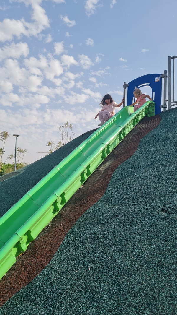 Children play at Kiryat Gat playground on sunny afternoon