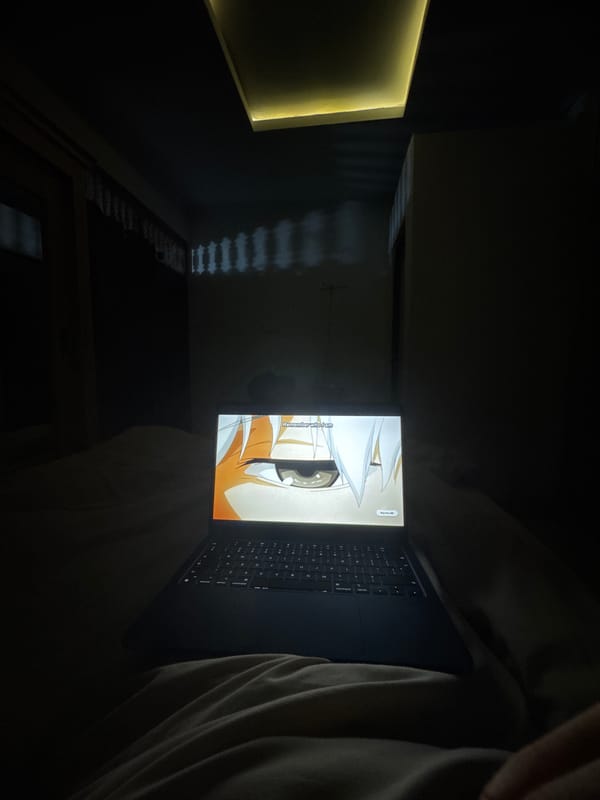 Person watches anime on laptop in dark room