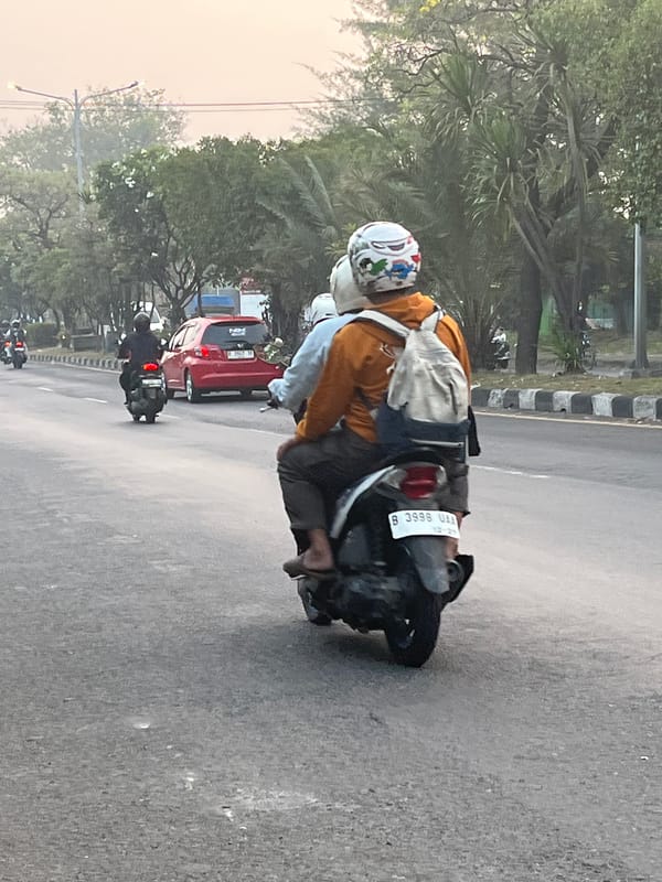 Dense motorcycle traffic flows through East Java streets at night