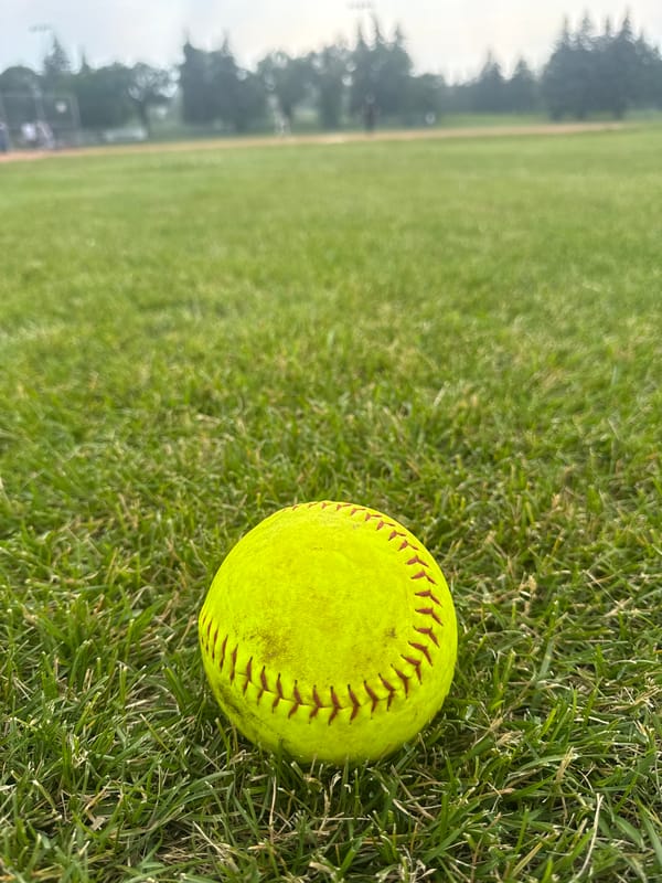 Casual softball game on a cloudy Canada Day evening