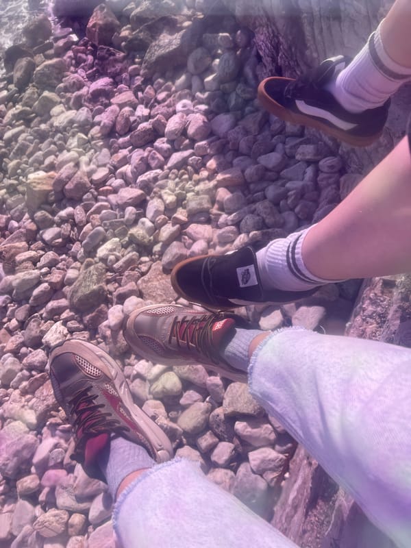 Three friends gather on gravel beach in Budva