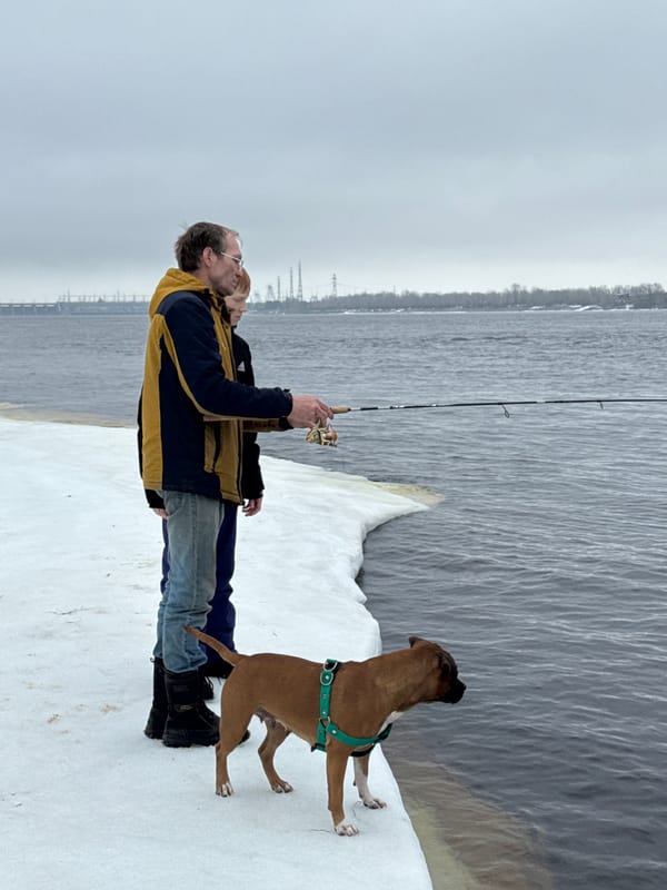 Family fishing trip with playful dog on frozen Russian reservoir