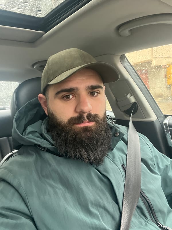 Man in green jacket sits in car during rain in Dobrich