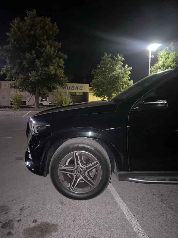 Black Mercedes GLE parked outside a Ruse car wash at night