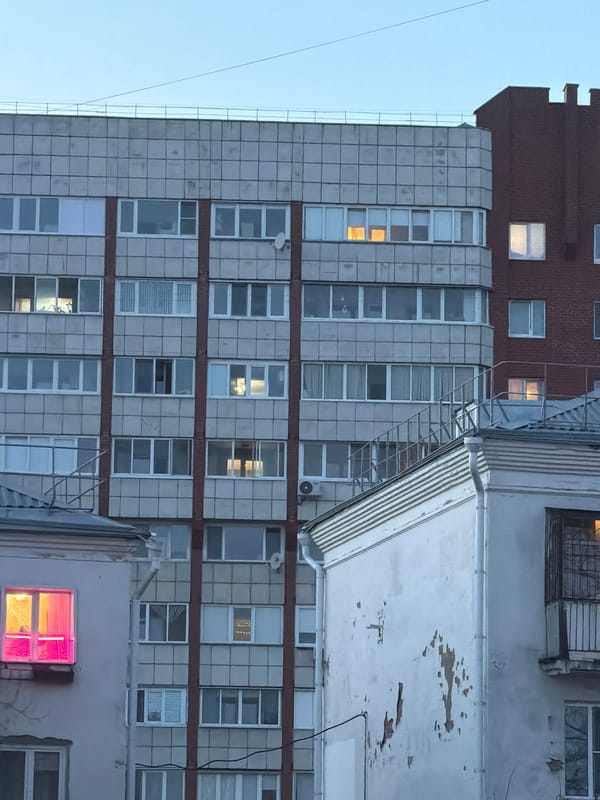 Multi-story building with lit windows observed in Perm