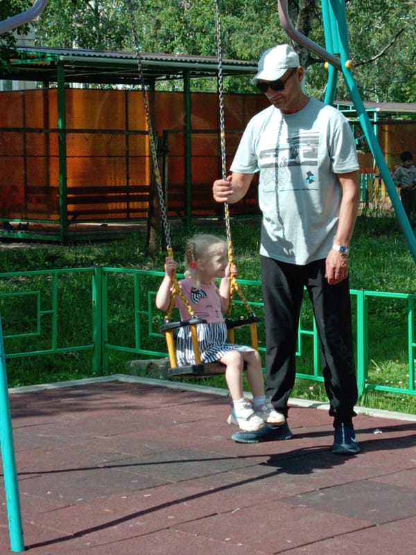 Father and daughter enjoy morning playground visit in Artyom
