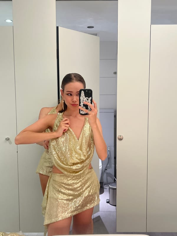 Woman takes bathroom selfie in gold dress in Vietnam