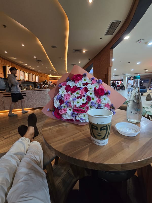 Person enjoys cafe time with flowers in Kuta