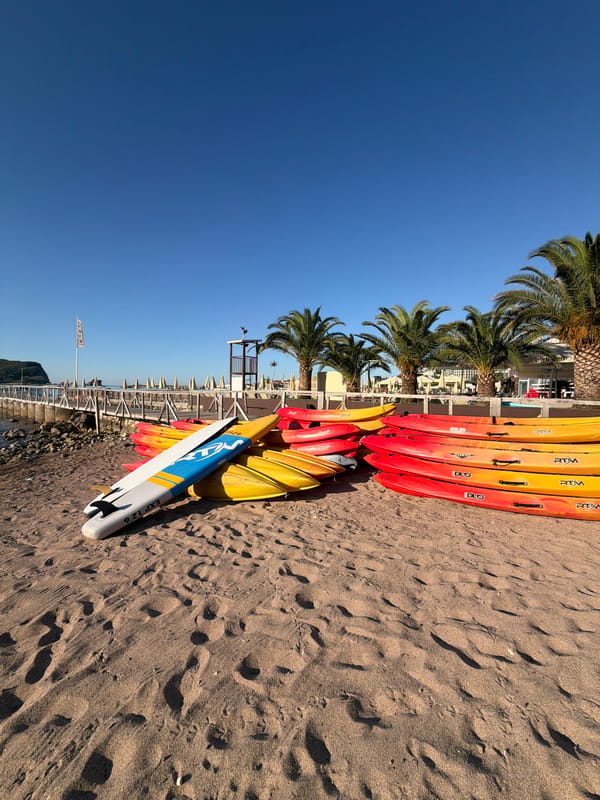 Kayaks and paddleboards staged on a sunny Budva beach