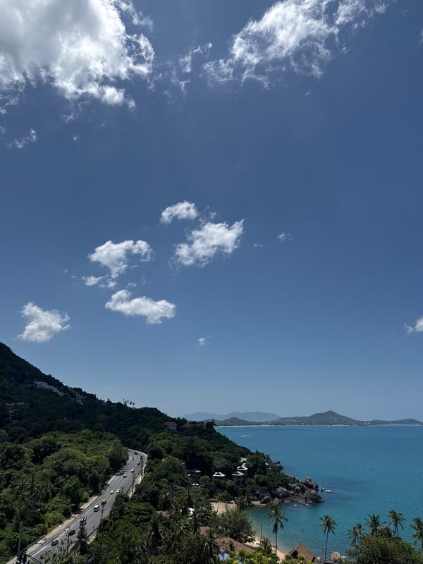 Winding coastal road cuts through Ko Samui on a clear day