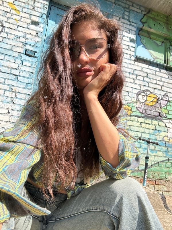 Woman resting against painted brick wall in Khimki