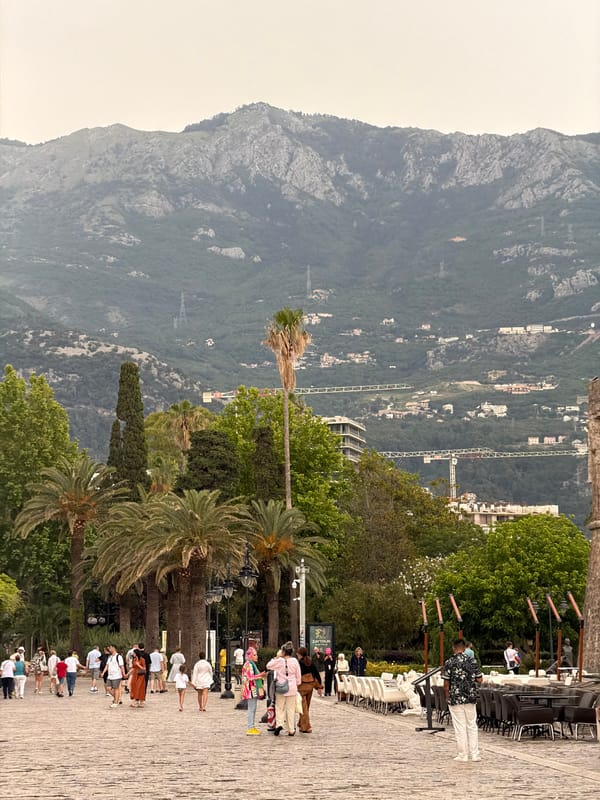 Tourist documents historic and modern Budva during afternoon walk