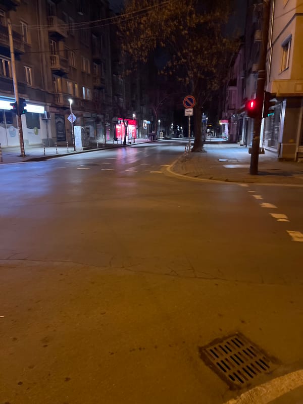 Wet street reflects city lights in nighttime Sofia