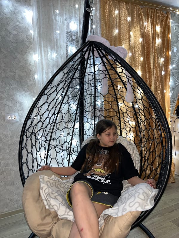 Young person photographed at home in hanging chair