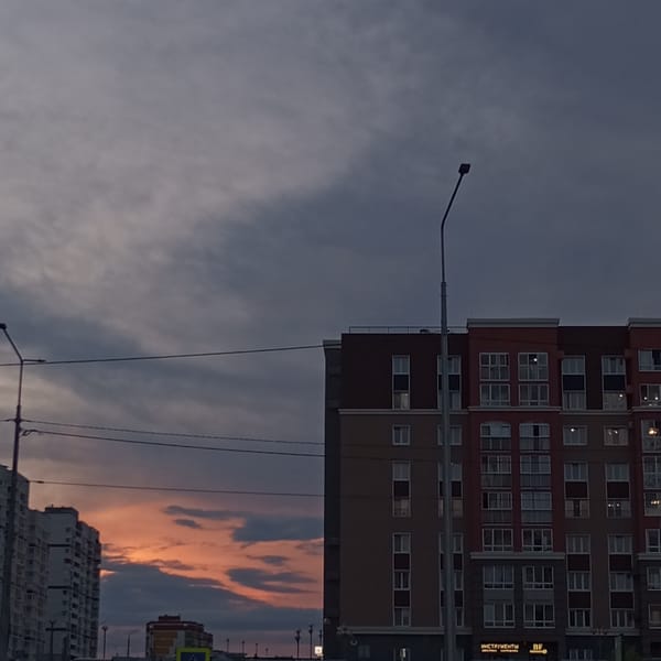Father-daughter badminton game captured at dusk in Pervomaysky
