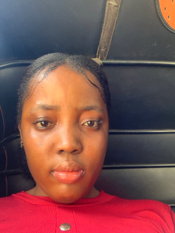 Woman takes selfie in red shirt in Aba, Nigeria