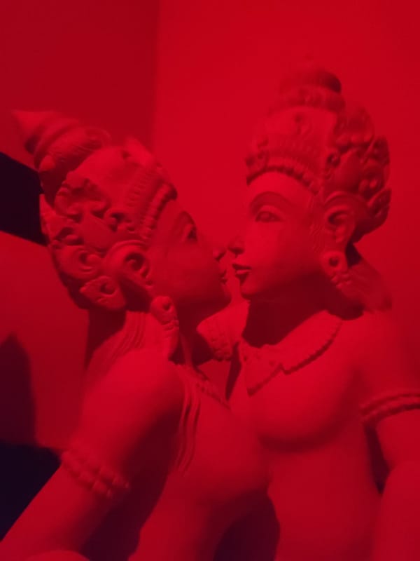 Stone statues photographed under red lighting in Ubud